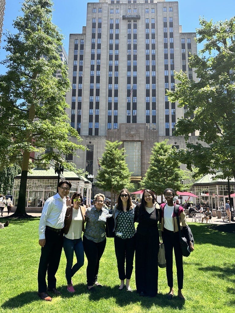 Photograph of five staff members smiling in Boston's Post Office Square